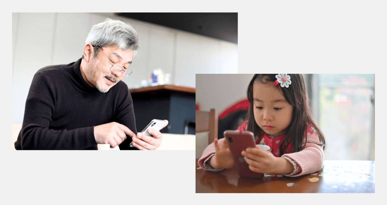 高齢者と子供がスマートフォンを操作しているイメージ写真